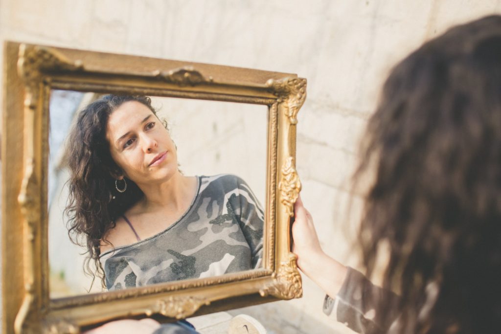 mujer mirando su rostro en un espejo