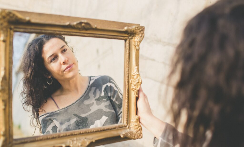 mujer mirando su rostro en un espejo